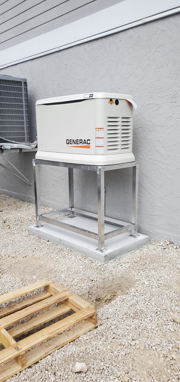 Generac standby generator on a metal frame anchored to a concrete base.