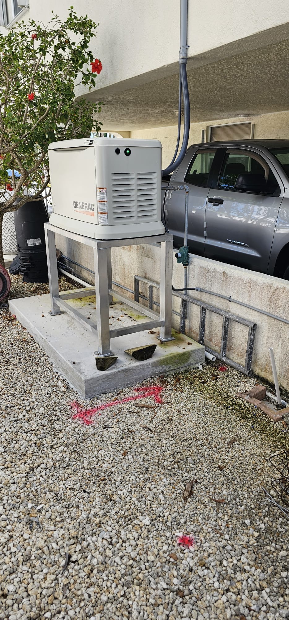 Generac standby generator mounted on an elevated metal support frame.
