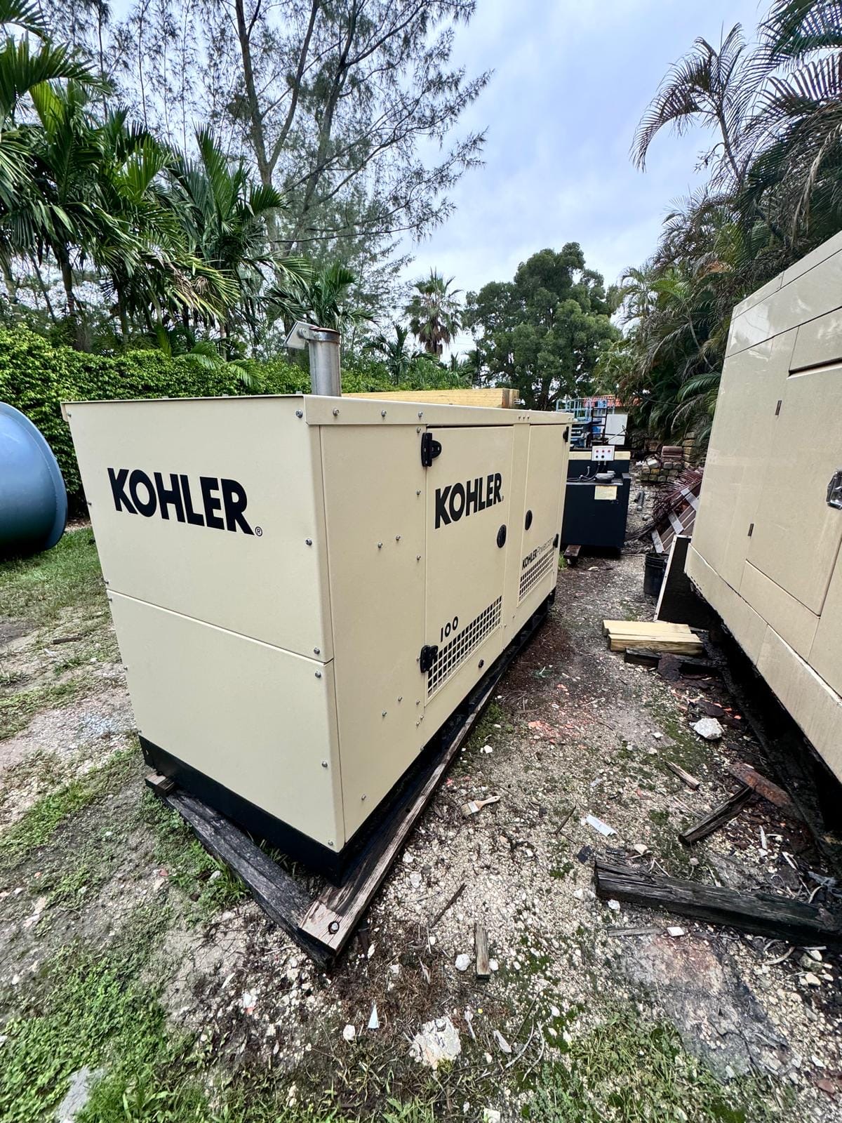 Large Kohler enclosed generator beside other generator equipment.