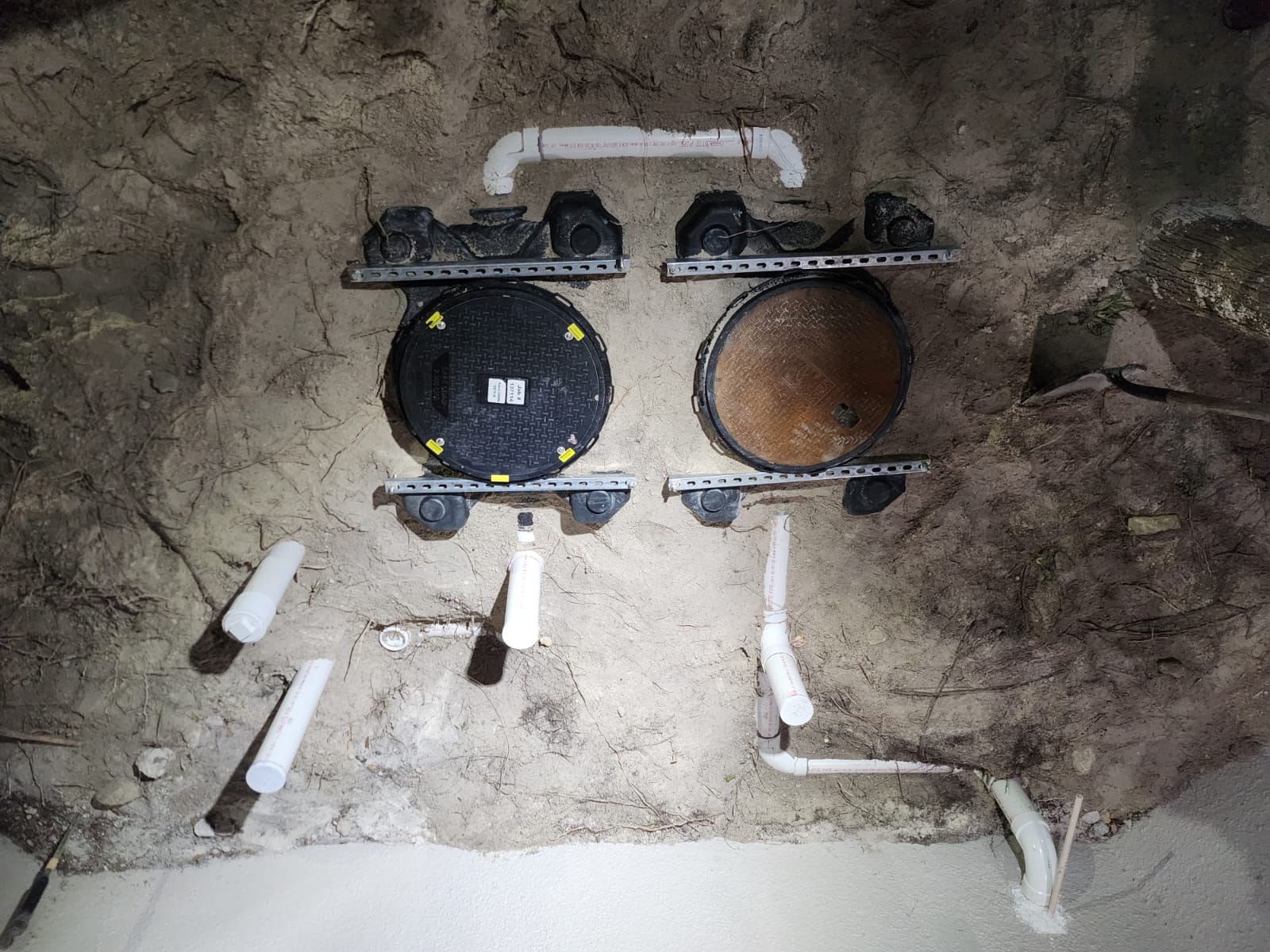 Grease trap lids and piping in excavated area