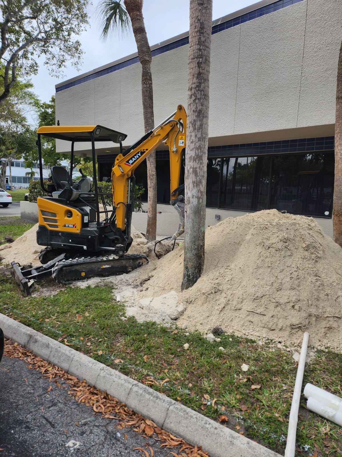 Excavator and soil piles at Global Meat Market grease trap project