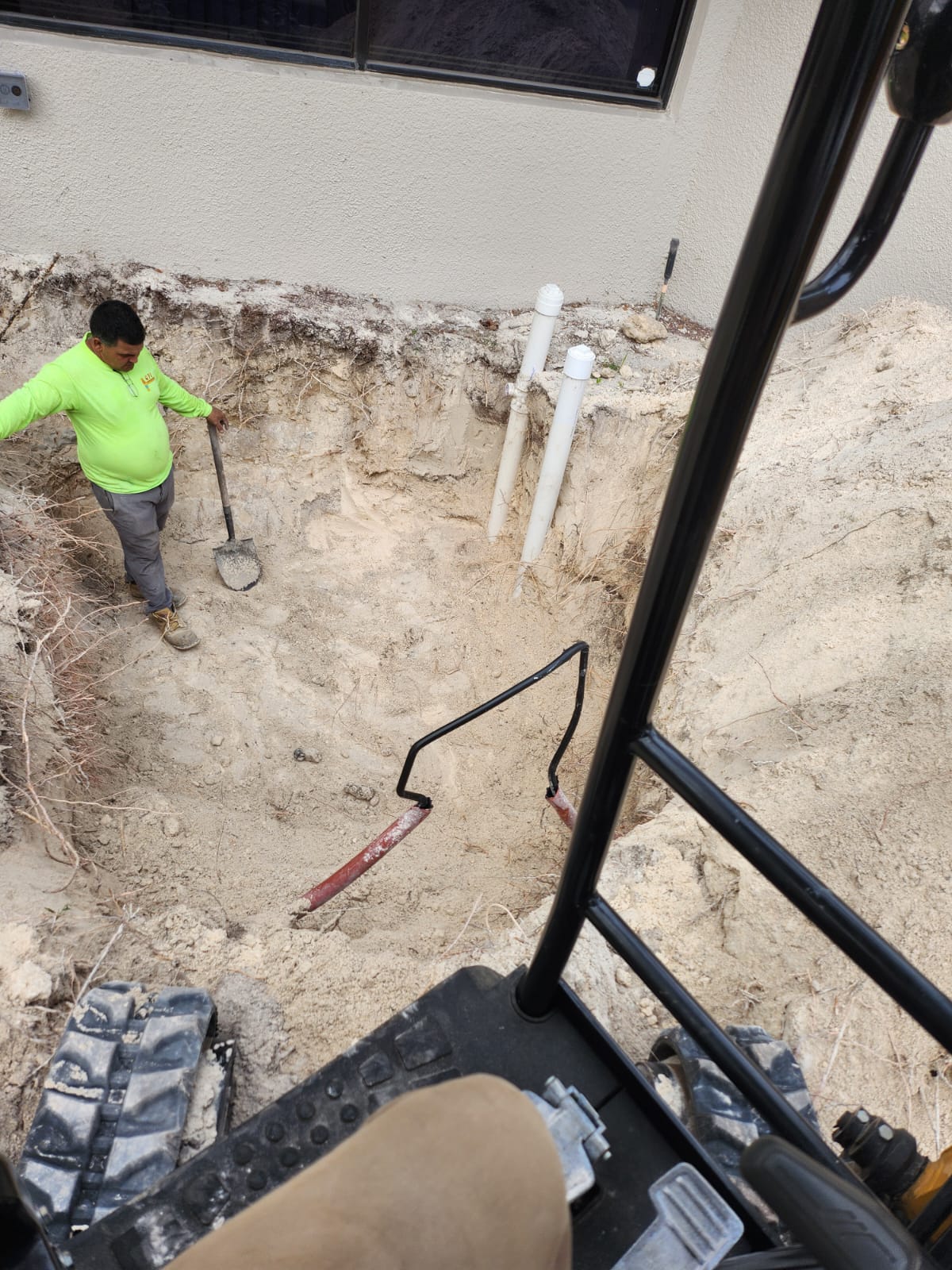 Worker inside excavation for grease trap installation
